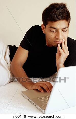 Man using laptop, hand on chin View Large Photo Image Stock Photograph - Man using laptop, hand on chin. Fotosearch