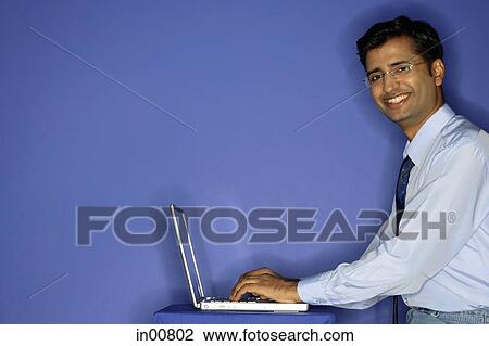 Man using laptop, smiling at camera View Large Photo Image Stock Image - Man using laptop, smiling at camera. Fotosearch