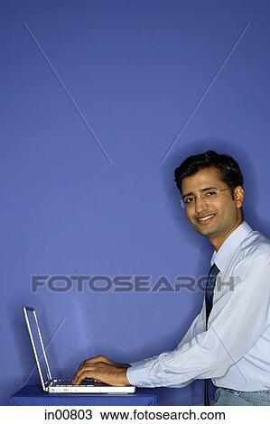 Man using laptop, smiling at camera, portrait View Large Photo Image Stock Image - Man using laptop, smiling at camera, portrait. Fotosearch