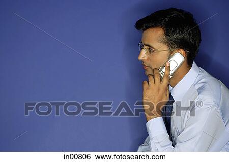 Stock Photograph - Man using mobile phone, side view. Fotosearch