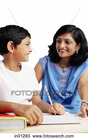 Son doing homework, turning to look at his mother View Large Photo Image Stock Image - Son doing homework, turning to look at his mother. Fotosearch