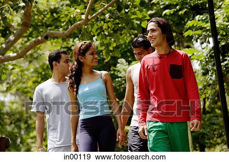 Stock Photo - Three guys and a girl on slide, walking side by side. Fotosearch