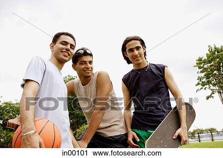 Stock Image - Three young men, looking at camera. Fotosearch