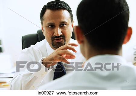 Two businessmen in office having a discussion, face to face View Large Photo Image Stock Photo - Two businessmen in office having a discussion, face to face. Fotosearch