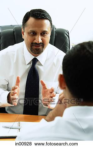 Stock Photo - Two businessmen in office talking. Fotosearch