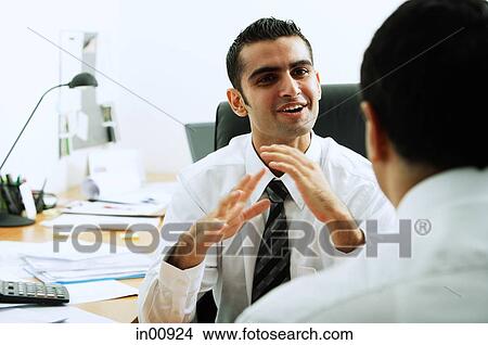 Two executives in office, talking face to face View Large Photo Image Picture - Two executives in office, talking face to face. Fotosearch