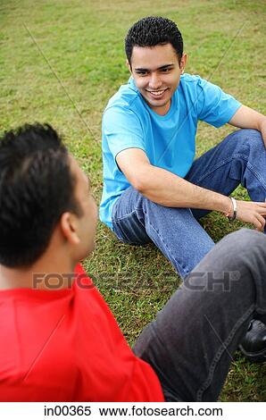 Two men sitting on grass, high angle view View Large Photo Image Stock Photography - Two men sitting on grass, high angle view. Fotosearch