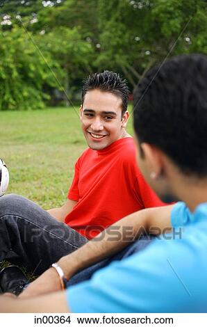 Two men sitting on grass, side by side View Large Photo Image Picture - Two men sitting on grass, side by side. Fotosearch
