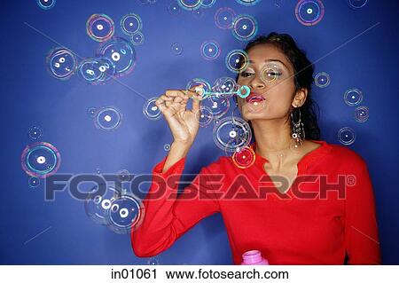 Woman blowing bubbles from bubble wand, bubbles all around her View Large Photo Image Stock Image - Woman blowing bubbles from bubble wand, bubbles all around her. Fotosearch