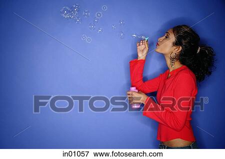 Woman blowing bubbles with bubble wand, side view View Large Photo Image Stock Photo - Woman blowing bubbles with bubble wand, side view. Fotosearch