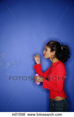 Woman blowing bubbles with bubble wand View Large Photo Image Stock Photograph - Woman blowing bubbles with bubble wand. Fotosearch