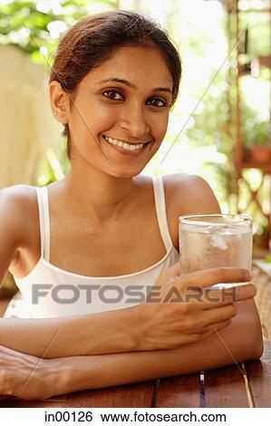 Woman holding glass of water, smiling View Large Photo Image Stock Photograph - Woman holding glass of water, smiling. Fotosearch
