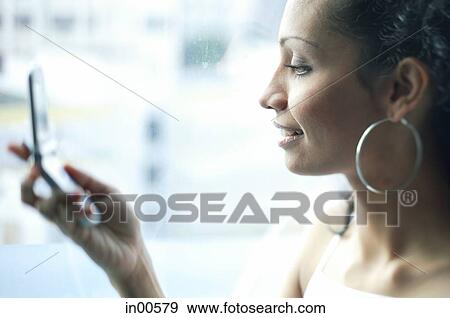 Stock Photo - Woman holding mobile phone, profile. Fotosearch