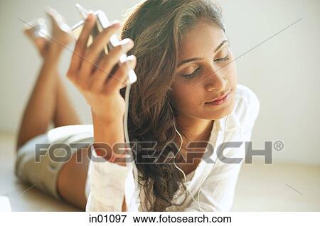 Woman listening to music from MP3 player View Large Photo Image Stock Photo - Woman listening to music from MP3 player. Fotosearch