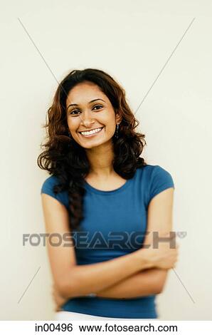Woman looking at camera, arms crossed, smiling View Large Photo Image Stock Photograph - Woman looking at camera, arms crossed, smiling. Fotosearch