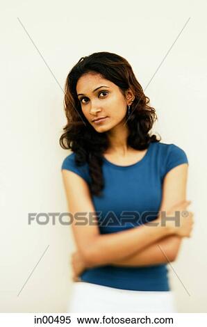 Stock Photography - Woman looking at camera, arms crossed. Fotosearch