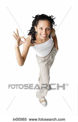 Woman looking at camera, making hand sign View Large Photo Image Stock Photography - Woman looking at camera, making hand sign. Fotosearch