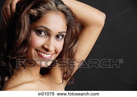 Woman looking at camera, smiling, hand on head View Large Photo Image Stock Photo - Woman looking at camera, smiling, hand on head. Fotosearch