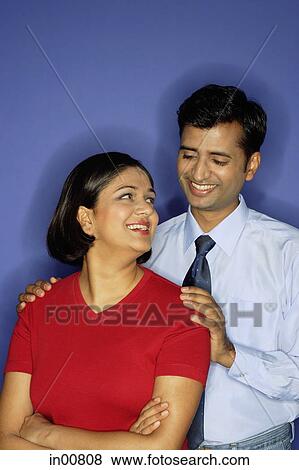 Stock Photo - Woman looking over shoulder at man behind her. Fotosearch
