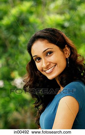 Stock Image - Woman smiling at camera, head shot. Fotosearch