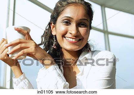 Woman smiling at camera, holding mug View Large Photo Image Stock Photography - Woman smiling at camera, holding mug. Fotosearch