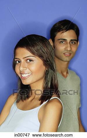 Woman smiling at camera, man standing behind her View Large Photo Image Stock Photo - Woman smiling at camera, man standing behind her. Fotosearch