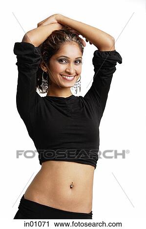 Woman standing with hands on head, looking at camera, smiling View Large Photo Image Stock Image - Woman standing with hands on head, looking at camera, smiling. Fotosearch