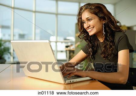 Stock Photo - Woman using laptop, smiling. Fotosearch