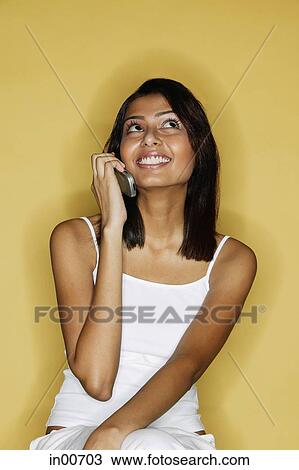 Woman using mobile phone, looking up View Large Photo Image Stock Image - Woman using mobile phone, looking up. Fotosearch