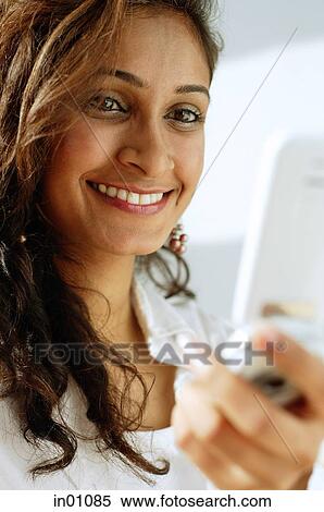 Stock Photography - Woman using mobile phone, smiling. Fotosearch
