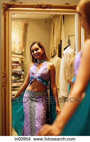 Woman wearing sari, looking at reflection in mirror View Large Photo Image Picture - Woman wearing sari, looking at reflection in mirror. Fotosearch