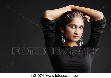 Picture - Woman with hands on head, head shot. Fotosearch