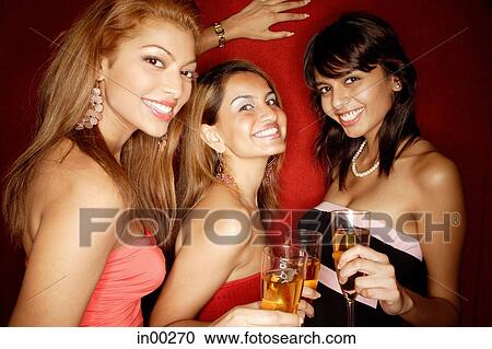 Women looking at camera, holding drinks, smiling View Large Photo Image Stock Image - Women looking at camera, holding drinks, smiling. Fotosearch