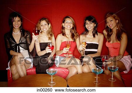 Women sitting in a row, holding drinks View Large Photo Image Stock Image - Women sitting in a row, holding drinks. Fotosearch