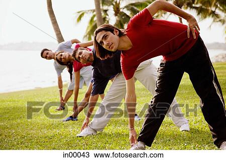 Stock Image - Young adults doing stretching exercises. Fotosearch