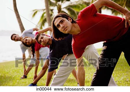 Picture - Young adults doing stretching exercises, bending sideways. Fotosearch