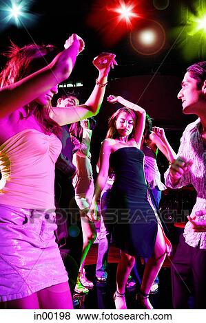 Stock Photo - Young adults in club, dancing. Fotosearch