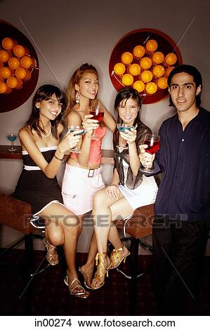 Picture - Young adults looking at camera, smiling and holding drinks. Fotosearch