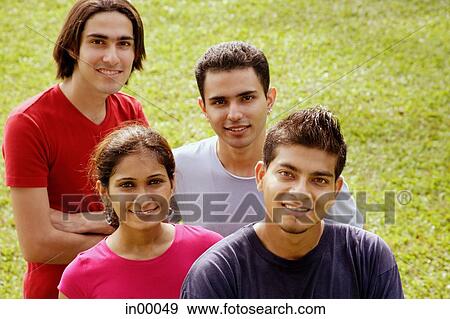 Stock Photo - Young adults looking at camera, smiling. Fotosearch