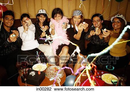 Young adults sitting side by side, celebrating, playing with streamers View Large Photo Image Stock Image - Young adults sitting side by side, celebrating, playing with streamers. Fotosearch