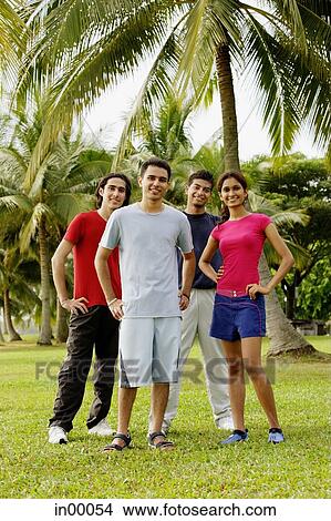 Young adults standing in park, looking at camera, hands on hips View Large Photo Image Picture - Young adults standing in park, looking at camera, hands on hips. Fotosearch