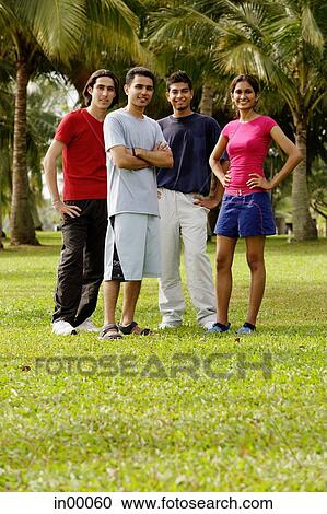 Young adults standing in park, looking at camera View Large Photo Image Stock Image - Young adults standing in park, looking at camera. Fotosearch