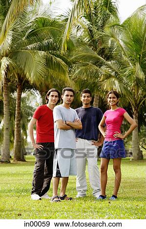 Young adults standing in park, looking at camera View Large Photo Image Stock Photo - Young adults standing in park, looking at camera. Fotosearch