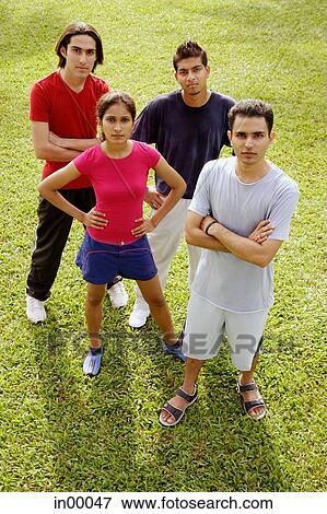 Stock Photo - Young adults standing, looking up at camera. Fotosearch