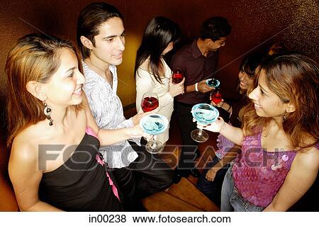 Young adults standing with drinks, talking View Large Photo Image Stock Photo - Young adults standing with drinks, talking. Fotosearch