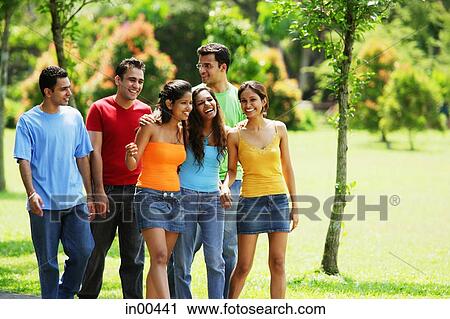 Young adults, walking in park View Large Photo Image Stock Image - Young adults, walking in park. Fotosearch