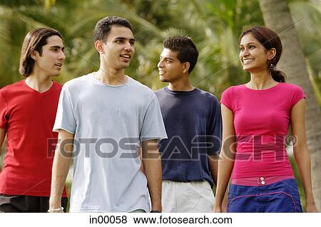Young adults walking in park View Large Photo Image Stock Photo - Young adults walking in park. Fotosearch