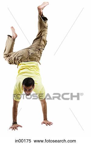 Young man balancing on his hands, legs up View Large Photo Image Stock Photography - Young man balancing on his hands, legs up. Fotosearch