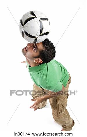 Young man balancing soccer ball on his head View Large Photo Image Picture - Young man balancing soccer ball on his head. Fotosearch