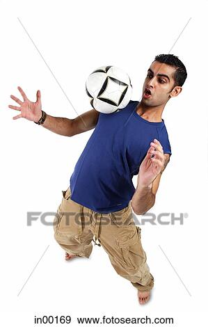 Stock Photo - Young man bouncing soccer ball on his chest. Fotosearch